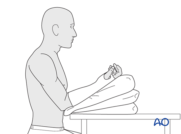 Sitting patient with forearm and wrist in a cast resting on pillows