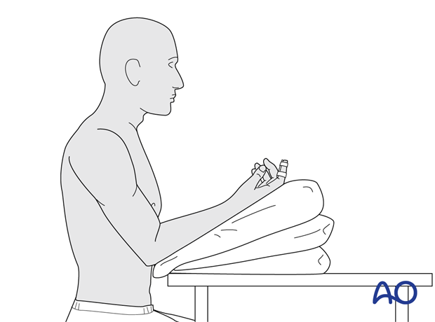 Sitting patient with forearm resting on pillows and a finger in a splint