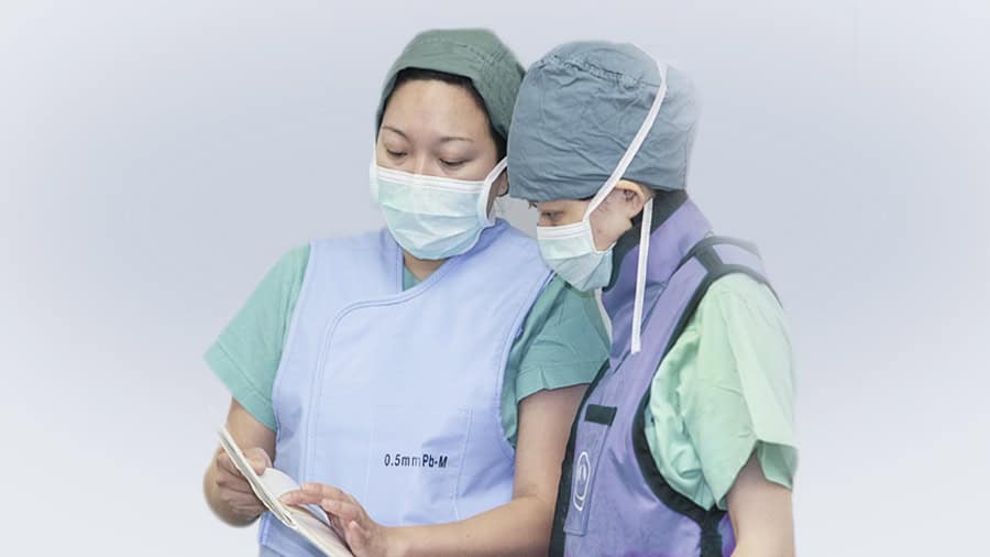 Operating room personnel discuss the healing report to monitor post-surgery recovery