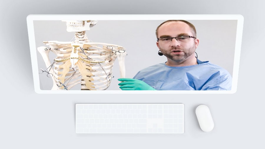A surgeon explains an upper extremities fracture using a skeleton during a webinar